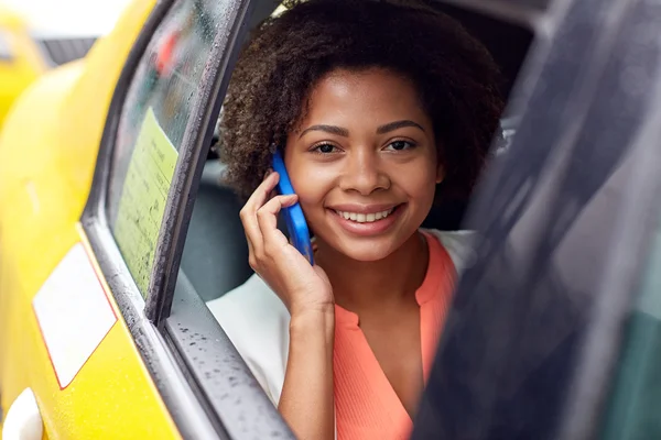 Glückliche Afrikanerin telefoniert im Taxi mit Smartphone — Stockfoto