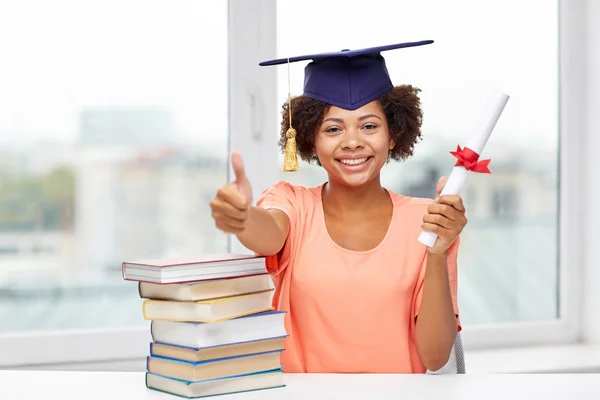 Happy african bachelor girl with books and diploma — Stock Photo, Image
