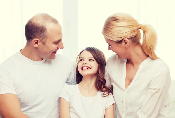 Sorrindo pais e menina em casa — Fotografia de Stock