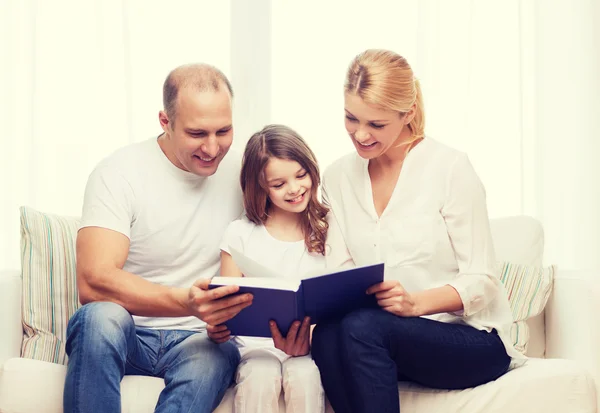 Genitori sorridenti e bambina con a casa — Foto Stock