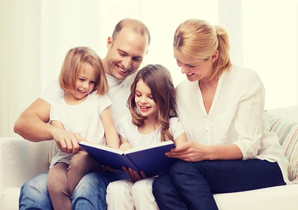 Familia sonriente y dos niñas con libro —  Fotos de Stock