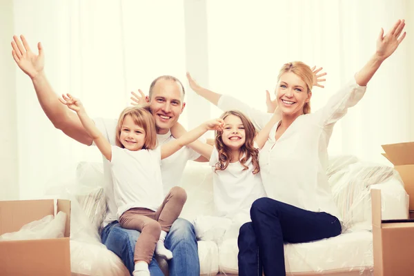 Smiling parents and two little girls at new home — Stock Photo, Image