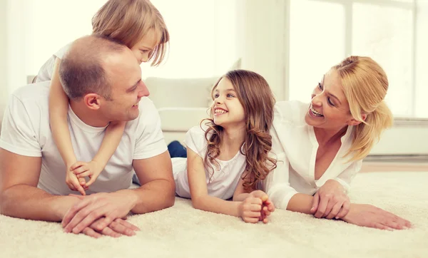 Rodiče a dvě dívky, které leží na podlaze doma — Stock fotografie