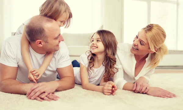 Genitori e due ragazze sdraiate sul pavimento a casa — Foto Stock