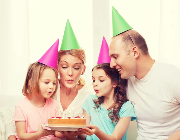 Χαμογελώντας οικογένεια με δύο παιδιά σε καπέλα με κέικ — Φωτογραφία Αρχείου
