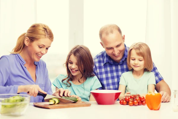 Familia feliz con dos niños haciendo la cena en casa — Foto de Stock