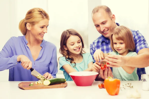 Familia feliz con dos niños haciendo la cena en casa — Foto de Stock