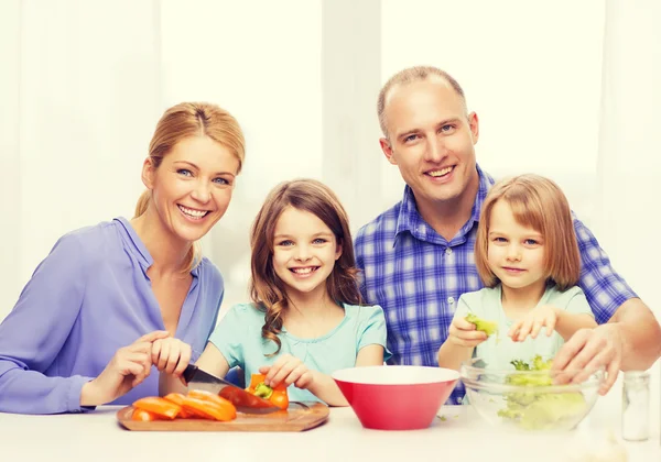 Família feliz com dois filhos fazendo o jantar em casa — Fotografia de Stock