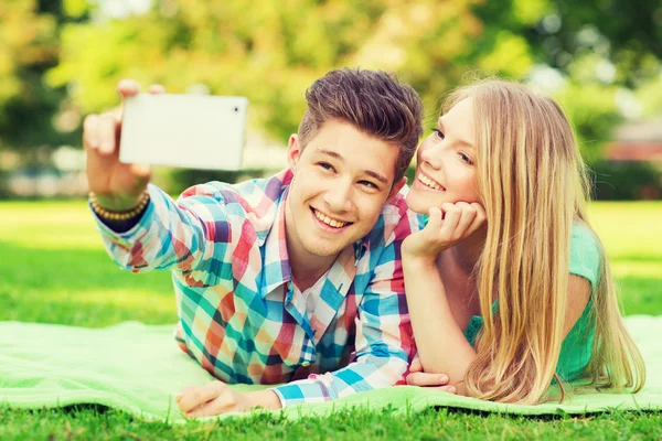 Lachende paar maken van selfie in park — Stockfoto