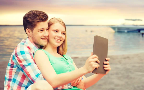 Casal com tablet pc tomando selfie sobre praia — Fotografia de Stock