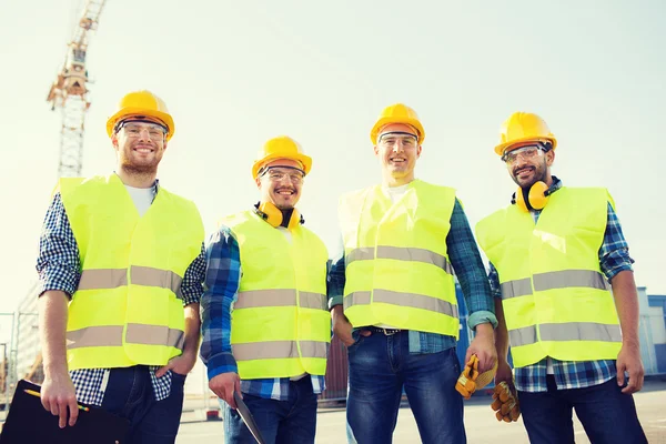 Группа улыбающихся строителей с планшетным ПК на открытом воздухе — стоковое фото