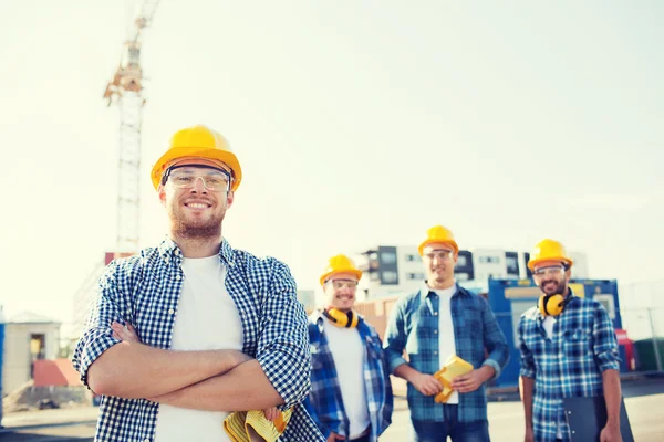 Groupe de constructeurs souriants en hardhats à l'extérieur — Photo