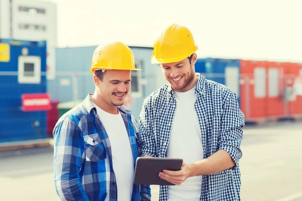 Constructeurs souriants en hardhats avec tablette pc — Photo