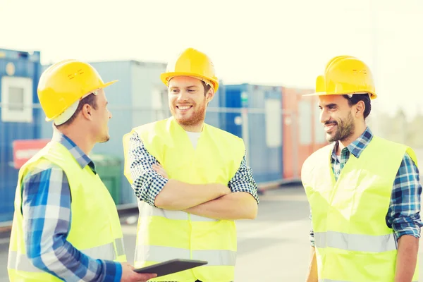 Constructeurs souriants en hardhats avec tablette pc — Photo