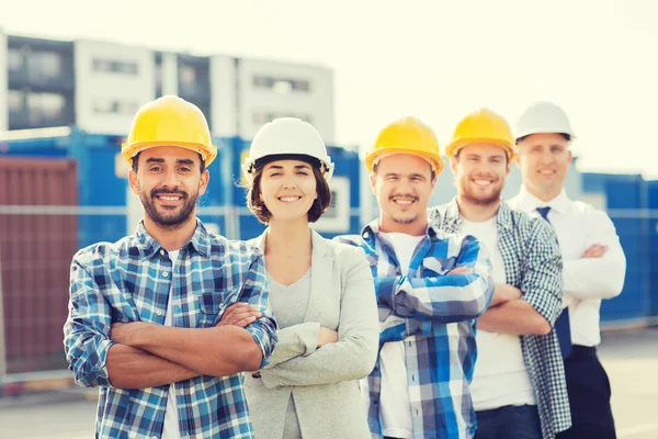 Gruppo di costruttori sorridenti in hardhats all'aperto — Foto Stock