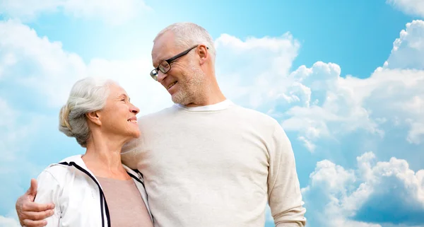 Happy senior couple over blue sky and clouds — 图库照片