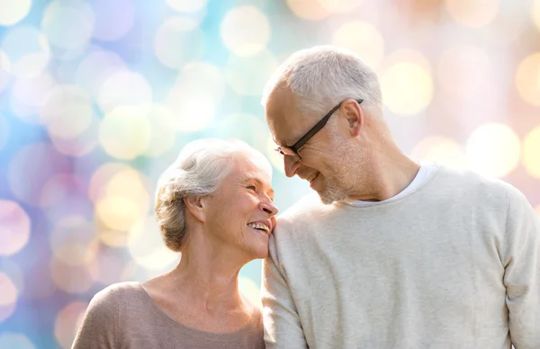 Happy senior couple over holidays lights — Stockfoto