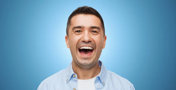 Laughing man over blue background — Zdjęcie stockowe