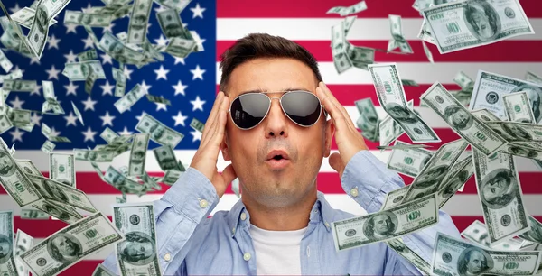 Surprised man under money rain over american flag — Stock fotografie