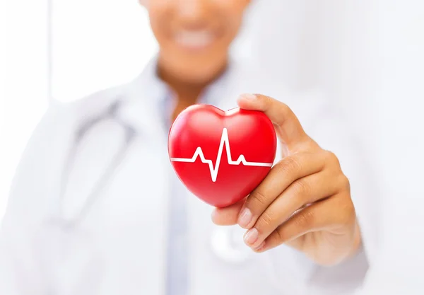 Médico femenino sosteniendo el corazón rojo con línea ecg — Foto de Stock