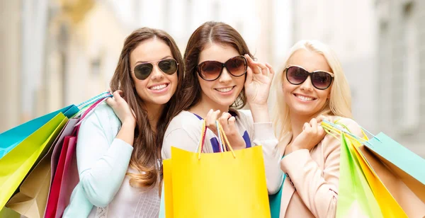 Tre ragazze sorridenti con shopping bags in ctiy — Foto Stock