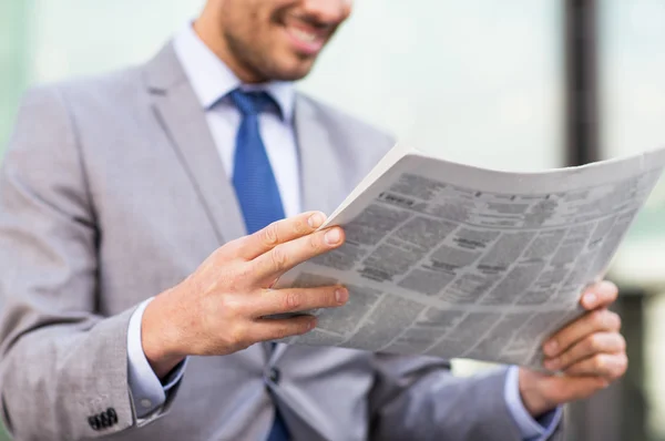 Primer plano del sonriente hombre de negocios leyendo el periódico — Foto de Stock