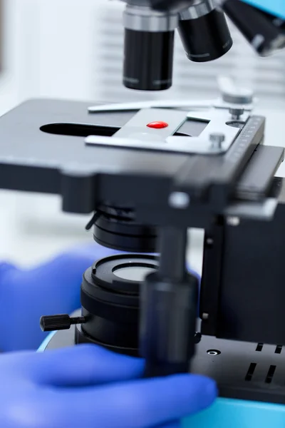 Primer plano de las manos con microscopio y muestra de sangre — Foto de Stock