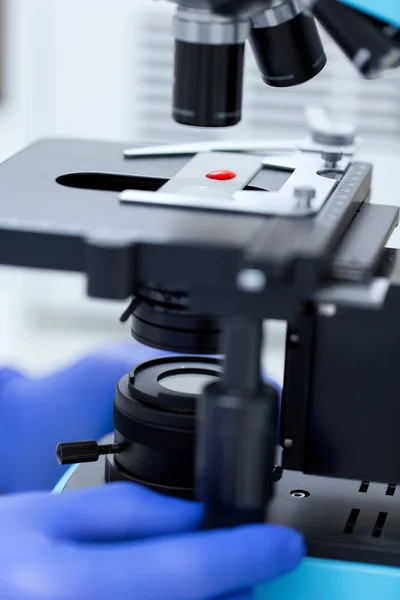 Close up of hands with microscope and blood sample — Stockfoto