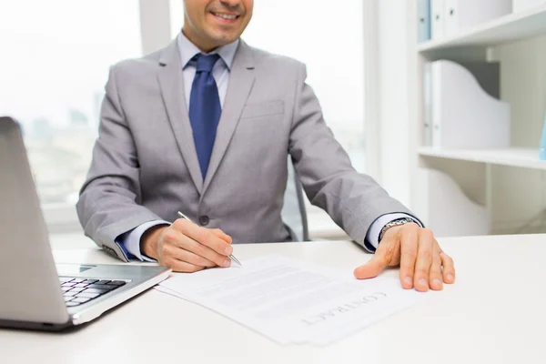 Primer plano de hombre de negocios con ordenador portátil y papeles —  Fotos de Stock