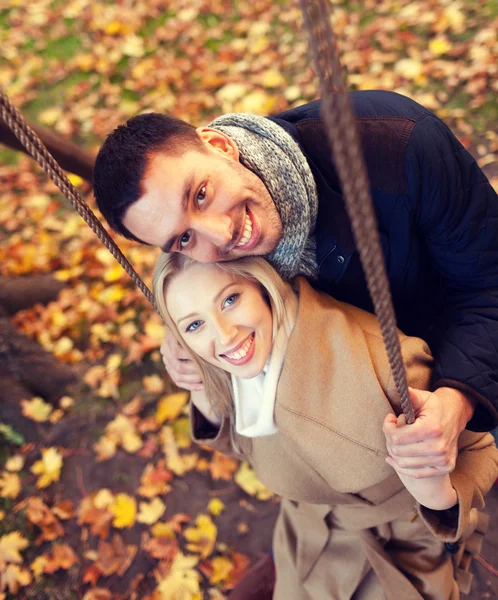 Casal sorridente abraçando no parque de outono — Fotografia de Stock