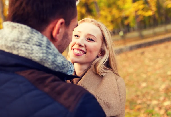 Uśmiechnięta para przytulająca się w jesiennym parku — Zdjęcie stockowe