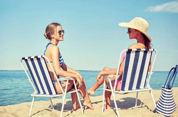 Szczęśliwe kobiety opalanie w salonach na plaży — Zdjęcie stockowe