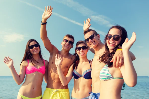 Lachende vrienden in zonnebril op zomer strand — Stockfoto