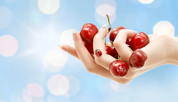 Female hand full of red cherries — 图库照片