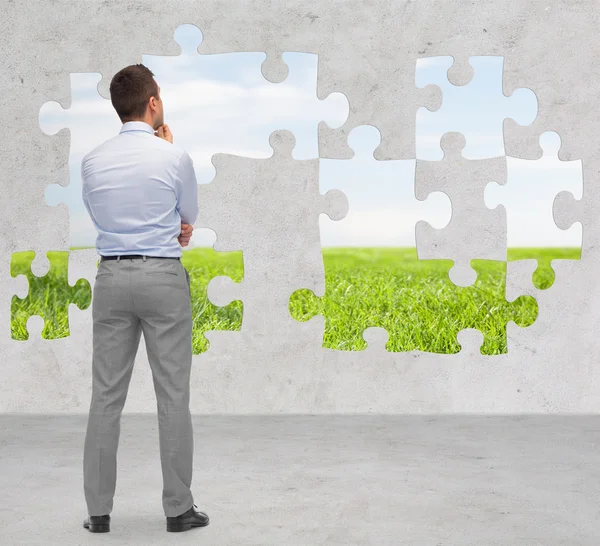 Businessman over puzzle with natural landscape — Stock Photo, Image