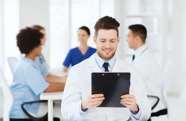 Médico feliz com tablet pc sobre a equipe na clínica — Fotografia de Stock