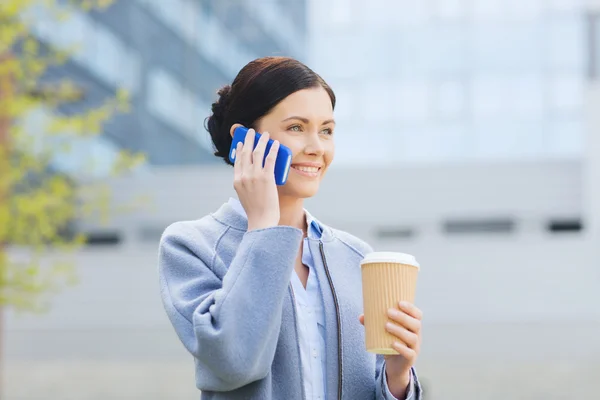 Lächelnde Frau mit Kaffee am Smartphone — Stockfoto