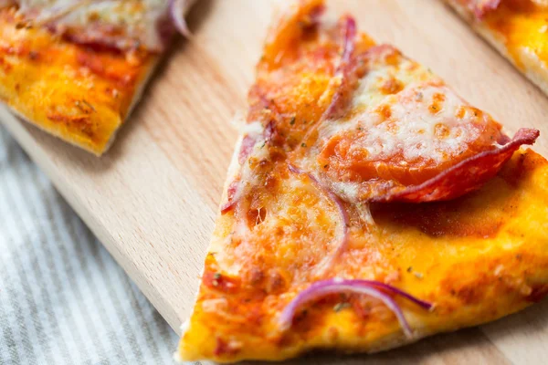 Close up de fatia de pizza caseira na mesa de madeira — Fotografia de Stock