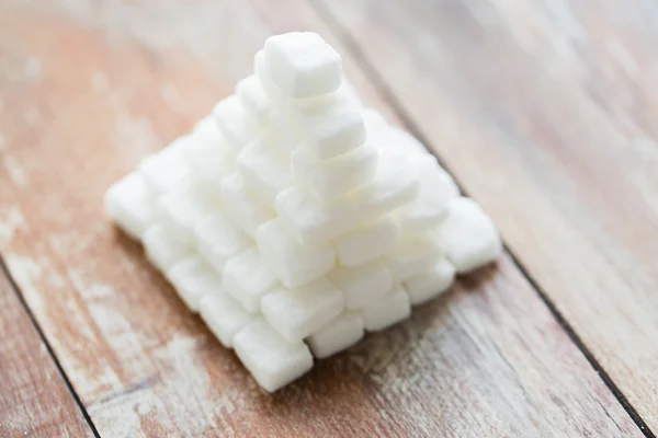 Close up de pirâmide de açúcar branco na mesa de madeira — Fotografia de Stock