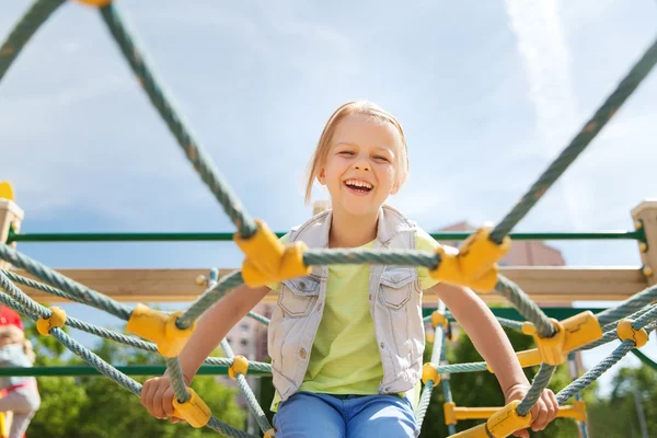 Felice bambina arrampicata sul parco giochi per bambini — Foto Stock