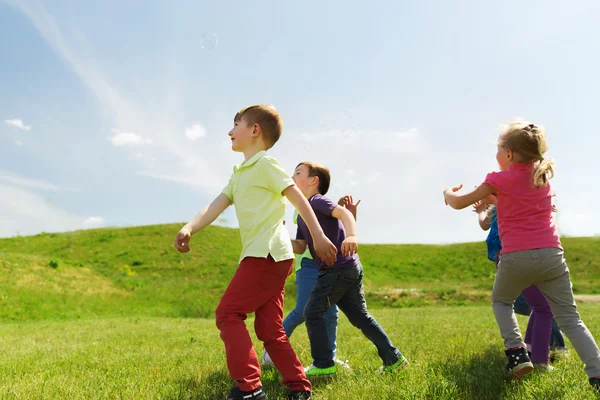 Gruppo di bambini felici che corrono all'aperto — Foto Stock