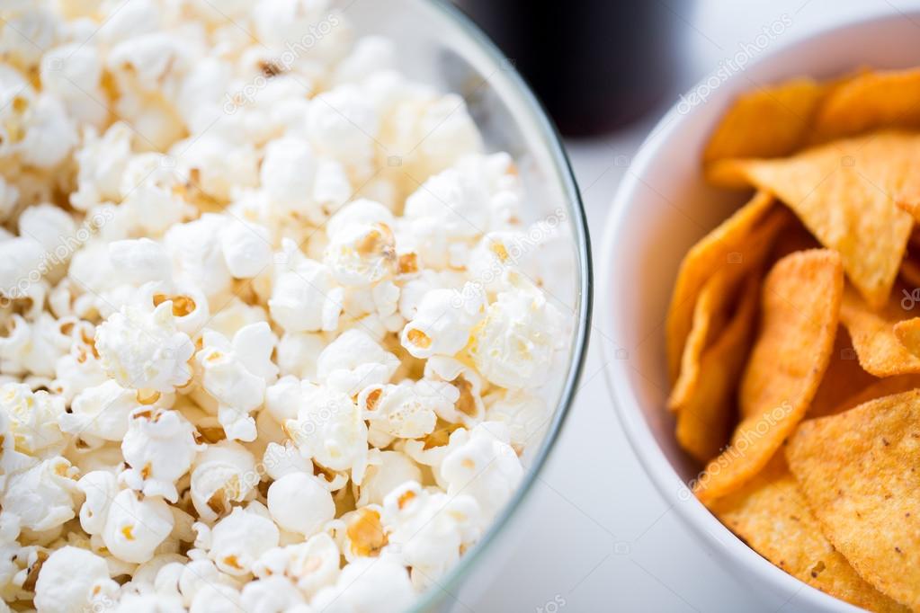 Close up of popcorn and corn crisps or nachos — Stock Photo © Syda