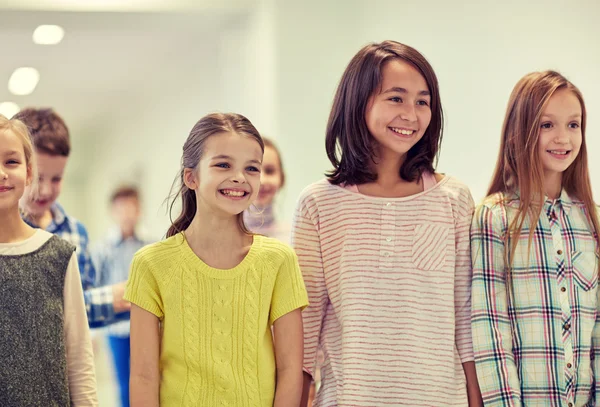 Groupe d'écoliers souriants marchant dans le couloir — Photo