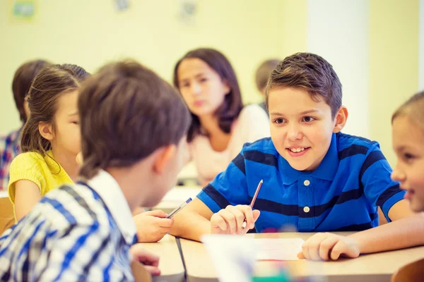 Groep van school-kids schrijven test in klas — Stockfoto