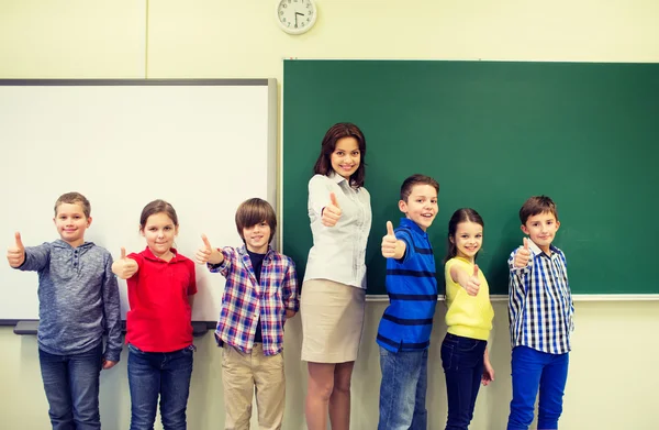 Group of school kids and teacher showing thumbs up — Stock Photo, Image