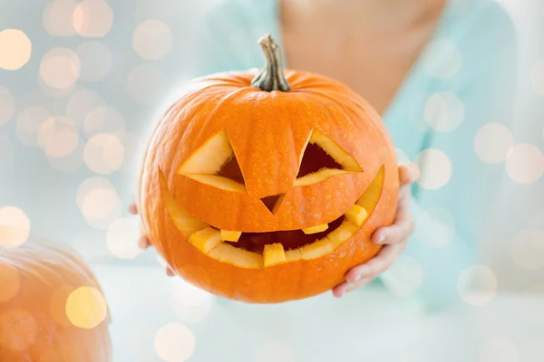 Close up of woman holding carved halloween pumpkin — ストック写真