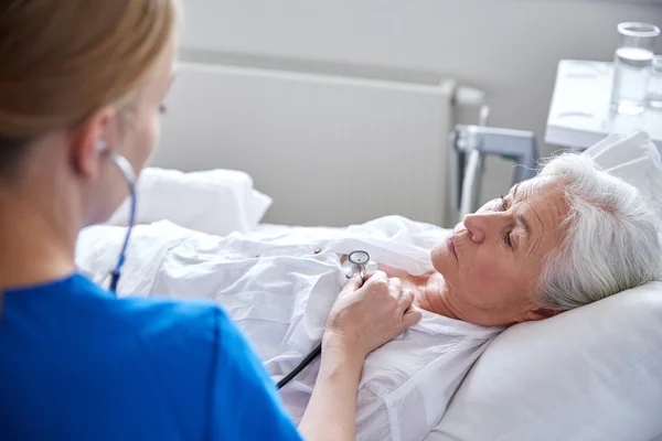 Stetoskop ve üst düzey kadın Kliniği ile hemşire — Stok fotoğraf