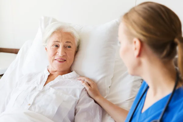 Doktor ya da hemşire yaşlı kadını hastanede ziyaret ediyor. — Stok fotoğraf