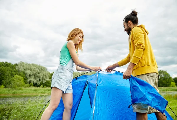 Couple heureux installant la tente à l'extérieur — Photo