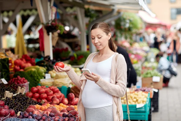 Schwangere mit Smartphone auf Wochenmarkt — Stockfoto